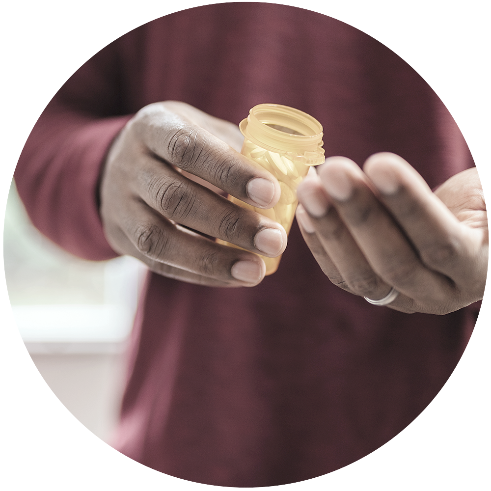 Man's hands holding open prescription bottle.