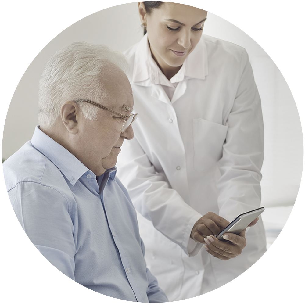 Woman in whitecoat showing an elderly man information on a phone.