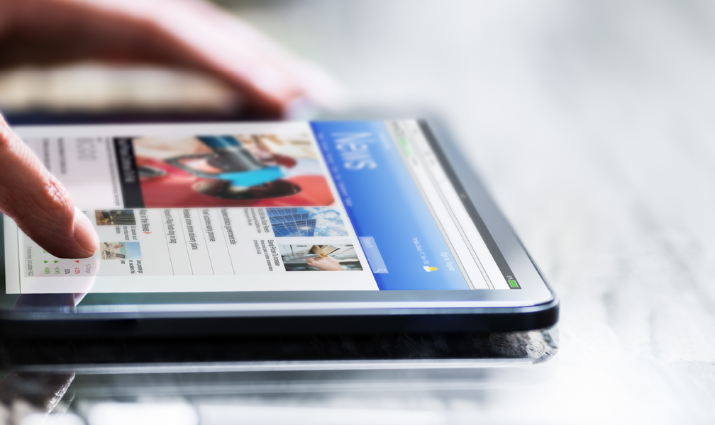 News page on smart tablet with hand scrolling