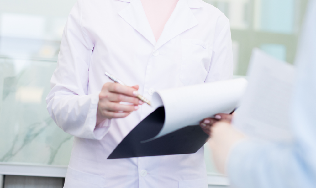 clinician holding clipboard in white lab coat