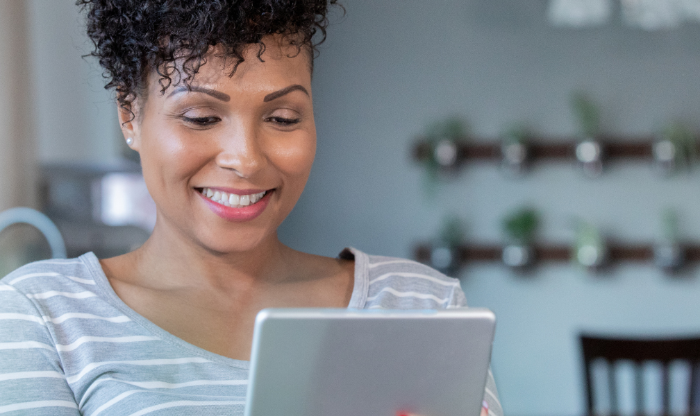 woman smiling at tablet in telehealth visit